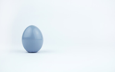 Gray easter egg isolated on white background. Chicken egg painted in gray color stands on surface, close up. Object for design to easter holiday