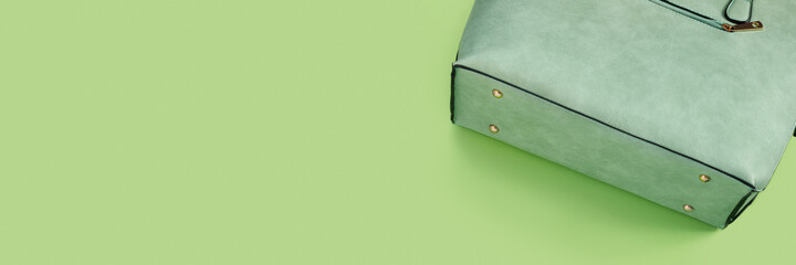 Beautiful fashionable green bag on delicate paper background.