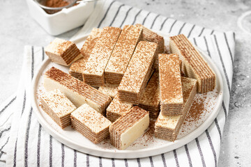 Waffles with chocolate and coffee filling in a white plate on a light background. Lots of wafers on the kitchen table	