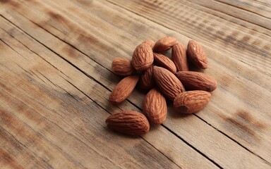 Several almonds on brown background