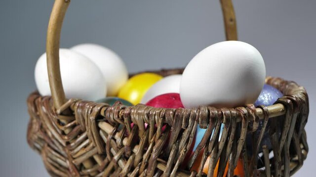 Colored eggs rotate in a basket. Easter eggs in all colors