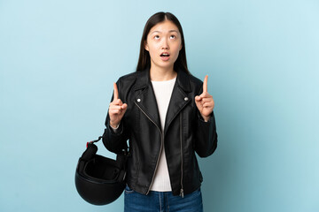 Chinese woman holding a motorcycle helmet over isolated blue background pointing with the index finger a great idea