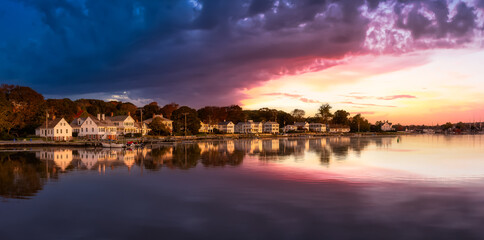 Panoramic view of residential homes by the Mystic River. Colorful Magical Sunrise Sky Art Render....