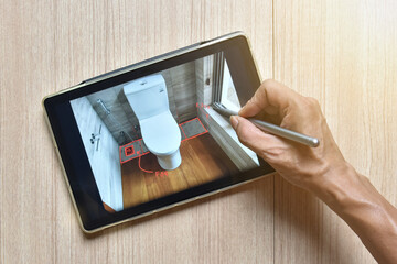 a tablet showing hand sketch of architectural drawing design detail with digital pens on wood table, the concept of new technology for working of tablet with digital pen