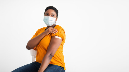 Vaccinated Black Woman Showing Arm With Adhesive Bandage, White Background