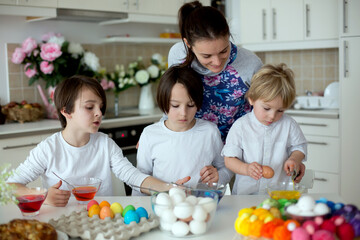 Obraz na płótnie Canvas Children, boy siblings, coloring eggs for Easter