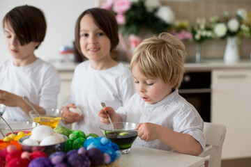 Children, boy siblings, coloring eggs for Easter