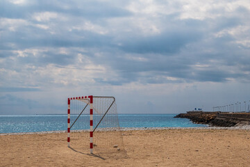 Soccer goal, on a lonely beach with the Mediterranean sea and a cloudy sky.