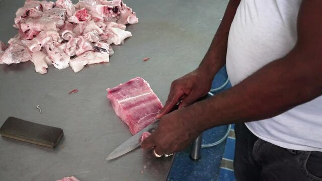 Afroamerican Male hands cutting fresh meat, Close-up of hands slicing red fish fillets on a wooden cutting board