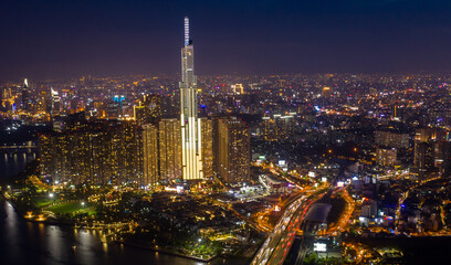 Obraz premium pic evening aerial panorama of Saigon, Ho Chi Minh City, Vietnam featuring all key buildings of the city skyline and the Saigon riverfront with beautiful light reflections on the calm water