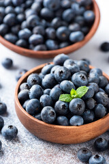 Fresh blueberries in a wooden bowl, closeup view. Healthy summer berries