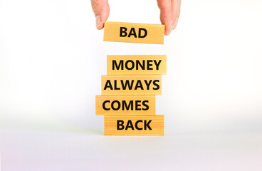 Business concept growth success process. Wood blocks on white background, copy space. Businessman hand. Words 'bad money always comes back'. Conceptual image of motivation.