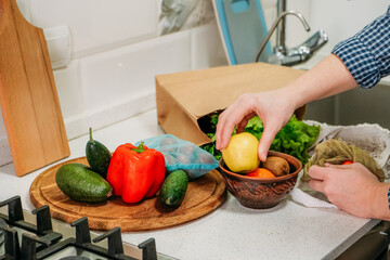 Food shopping, food e-commerce, home cooking, online grocery, supply chains, regional supermarket and farm store. Woman customer receiving order unpacks products for cooking in the kitchen at home