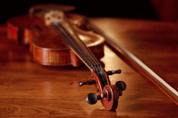 Fototapeta premium Violin in retro style on wooden table, closeup