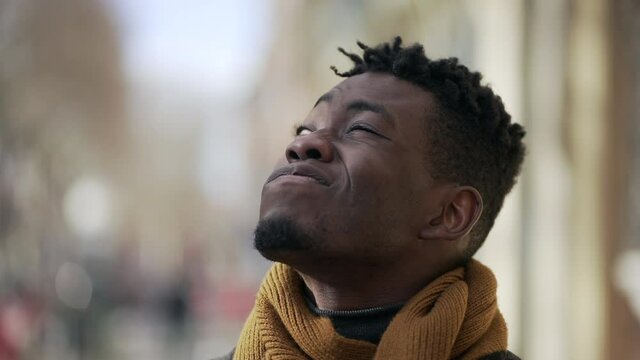 Black man squinting eyes while observing buildings