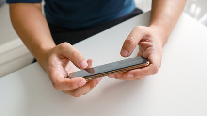 Man playing game on mobile phone. gamer boy playing video games holding Smartphone working mobile devices. cell telephone technology e-commerce concept