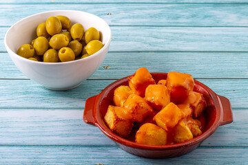 Spanish gastronomy concept. Clay plate with fried potatoes with a spicy sauce called in Spain 