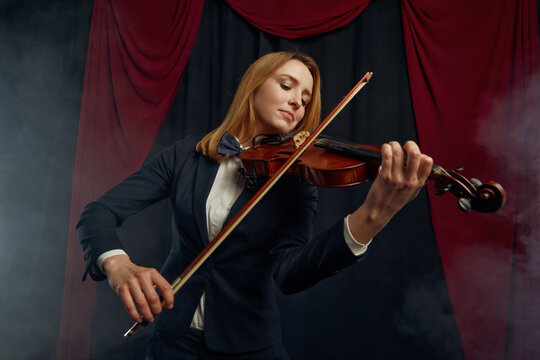 Female violonist with violin, performance on stage