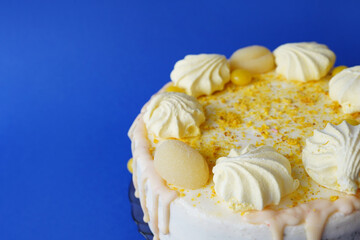Lemon cake with sugar powder and marshmallows on blue background