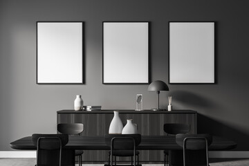 Grey dining room interior with black furniture, posters on grey wall