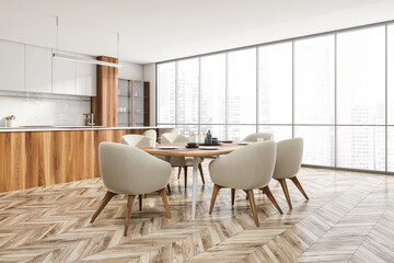 White wooden kitchen interior with eating table and kitchen set near window
