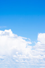Naklejka na ściany i meble Vertical format of background made of many white cumulus clouds on blue sky with gradient. Copy space