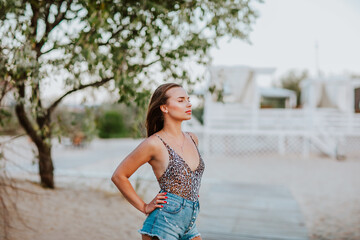 Woman in summer shorts and top posing on a seacoast in hotel. Copy space.