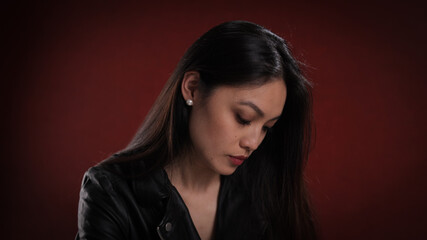 Fototapeta premium Young pretty woman in black leather jacket posing for the camera - studio photography