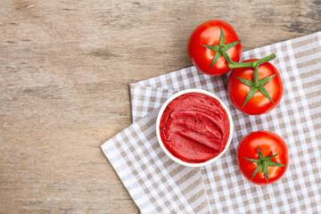 Tomato paste on wooden background.