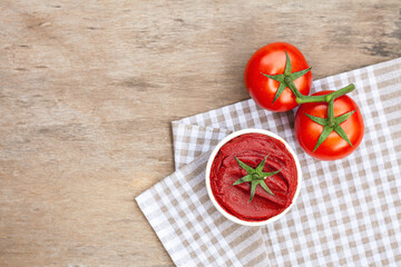 Tomato paste on wooden background.