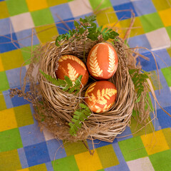 close-up easter eggs with ornament in a nest on the table