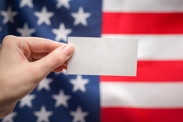 Empty card in woman hand. Copy space.  American flag background.