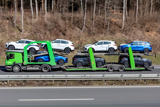 WIEHL, GERMANY - MARCH 24, 2021: Adampol Scania car-carrying truck loaded with new Kia Sportage cars on motorway.