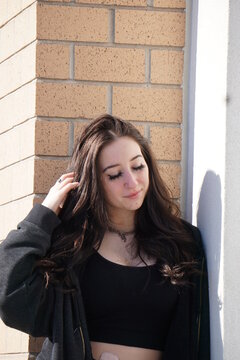 Girl leaning against wall in the sun