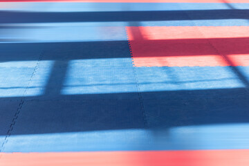 Sports background. Red-blue colors of traditional soft floor covering for karate, taekwono practice.
