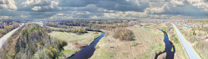 Fototapeta na wymiar brown river between meadow and spring forest