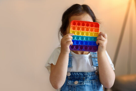 Cute Faceless Child Playing With The Pop It Fidget. Push Pop Bubble Flexible Fidget Sensory Toy Provide Discharge And Are Good For The Development Of Kid. Selective Focus On Toy.