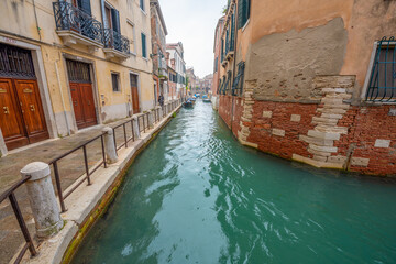 Venice, Italy - March 15, 2021 - A lone woman is the only person on a street in Venice, Italy during lockdown.