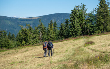 Fototapeta na wymiar A family walking on a hiking trail in Beskid Żywiecki
