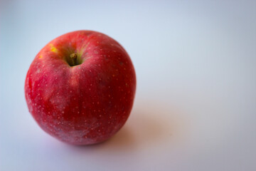 Red apple stand on a white surface