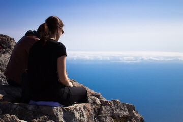 Naklejka na ściany i meble Two teenagers is sitting on top of the mountain.