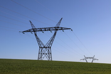 Pylônes électriques haute tension sur fond de ciel bleu, département du Rhône, France