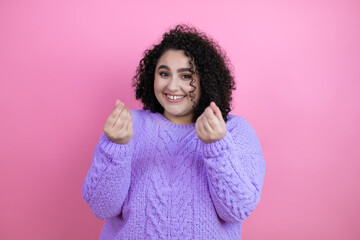 Young beautiful woman wearing casual sweater over isolated pink background doing money gesture with hands, asking for salary payment, millionaire business