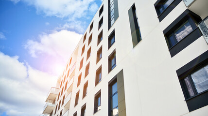 Facade of a modern apartment building. Glass surface with sunlight. Modern apartment buildings on a sunny day with a blue sky.