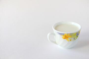 White mug with milk on a white background. White mug with flower print