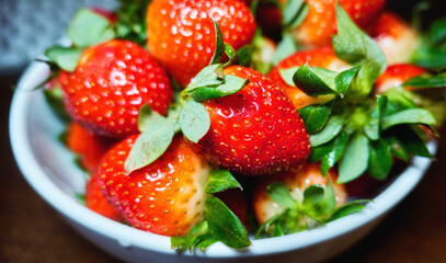 Juicy strawberry on white ceramic plate
