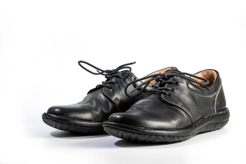Mans black leather shoes. Close-up of a pair of black sneakers or sport shoes with laces isolated on a white background. Elegant and trendy mens footwear