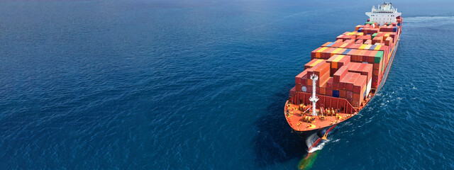 Aerial drone ultra wide photo of huge container ship cruising deep blue open ocean sea near...