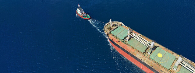 Aerial drone ultra wide photo of huge crude oil tanker ship guided by tug boats