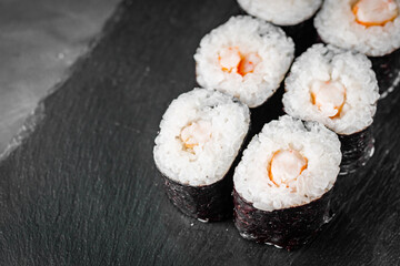 appetizing sushi shrimp maki roll on a black stone plate © Narsil